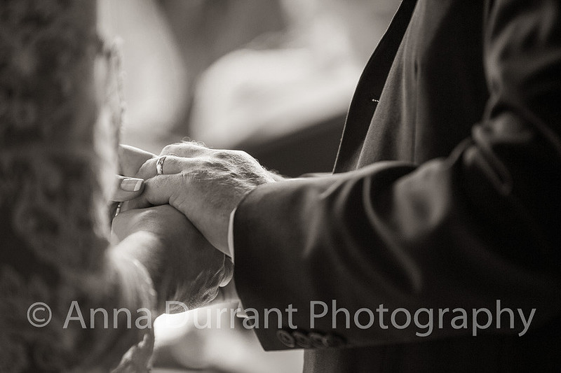 Bride and groom clasping hands during ceremony