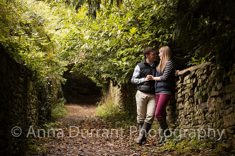 Young couple resting on wall on woodland path