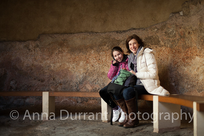 Mother and child sitting in alcove in The Roman Baths in Bath