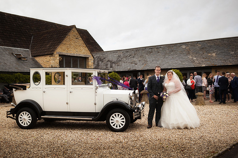 Couple by bridal car outside Winkworth Farm
