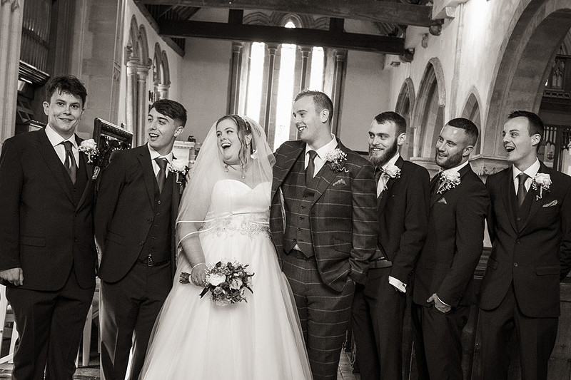 Black and white fun picture of ushers with bride and groom